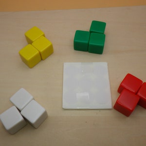 May include: Three sets of three colorful blocks, each set in a different color: yellow, green, and red. The blocks are arranged in a triangular shape.