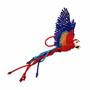 May include: A beaded parrot ornament in flight, featuring vibrant red, blue, yellow, and white beads. The bird has a curved red loop for hanging and long, flowing tail feathers. The wings are spread, showcasing the intricate beadwork.