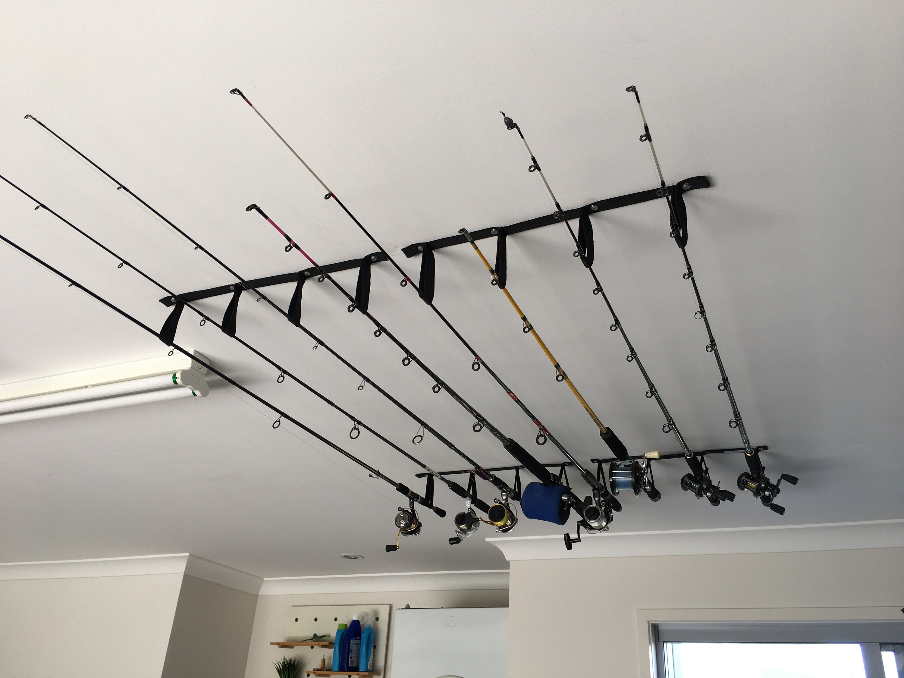 My dad made these ceiling mount fishing rod racks for me. All