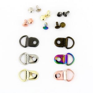 May include: Assortment of metal shoe eyelets and D-ring hardware in various finishes, including silver, gold, black, rose gold, and iridescent.