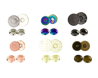May include: A collection of circular magnetic snap fasteners in various finishes including silver, iridescent rainbow, black, rose gold, gold, and antique bronze. Each set consists of two round metal components with engraved text.