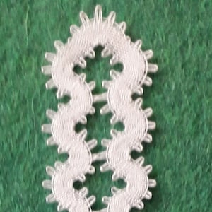 Può includere: Segnalibro in pizzo bianco lavorato a uncinetto con un bordo a festoni e un fiocco in basso.