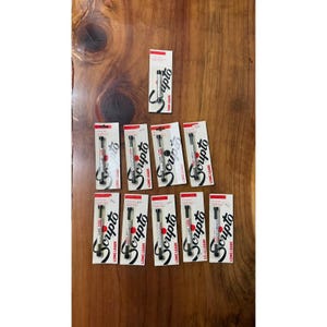 May include: Nine individual packages of Scripto mechanical pencil leads arranged in a grid. Each white cardboard backing features red accents and the black Scripto logo. The packages are labeled as either Thin Leads or Long Leads.