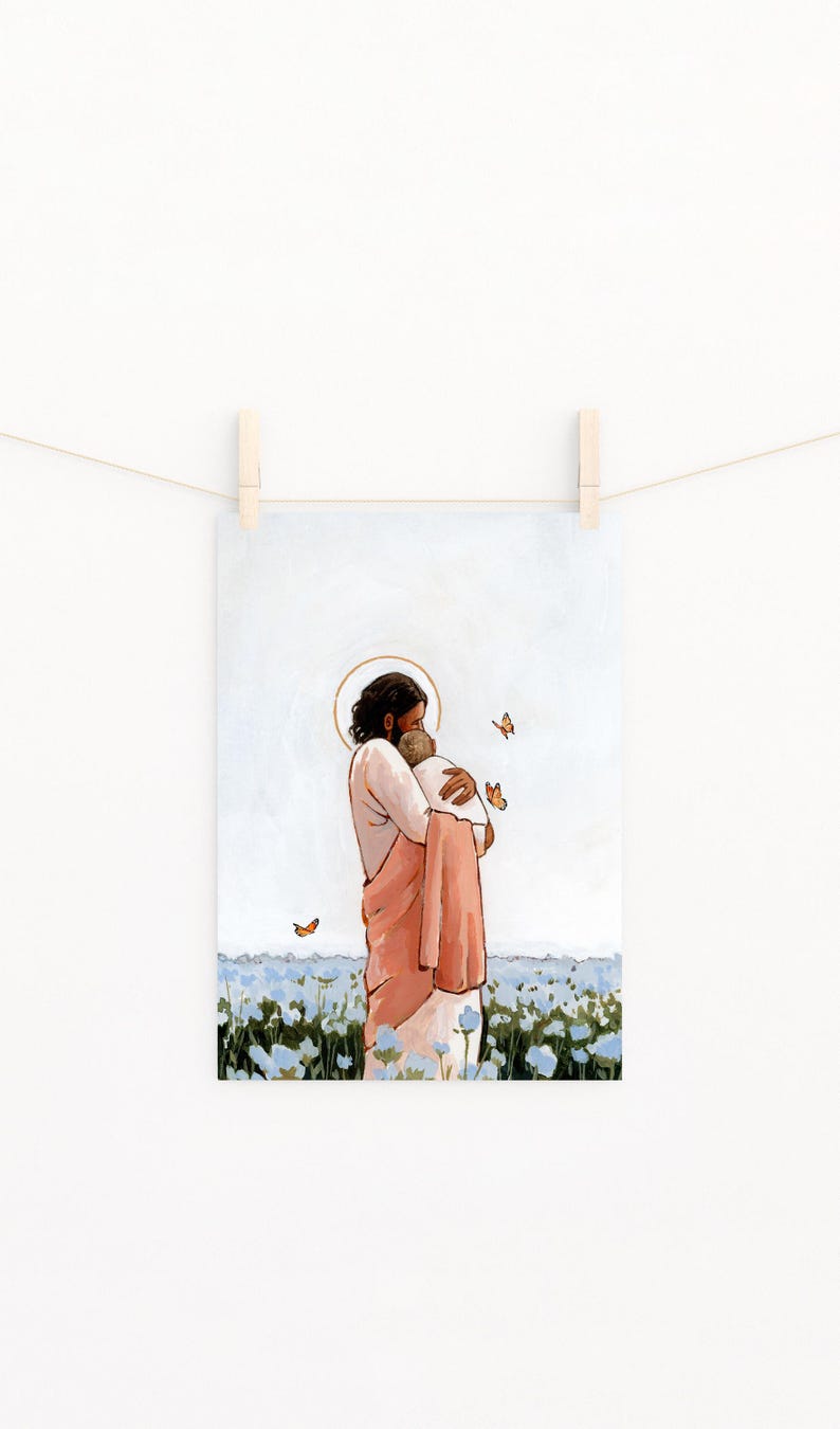Op de afbeelding: Een kunstdruk met een figuur in een perzikkleurige jurk die een andere figuur omhelst, beide met halo's. De achtergrond toont een veld met blauwe bloemen en oranje vlinders. De print hangt aan een waslijn met houten wasknijpers.
