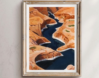 May include: Framed art print depicting a canyon landscape with a winding blue river. The artwork features warm orange and brown tones for the canyon walls, with touches of green vegetation. The frame is a light gold color.