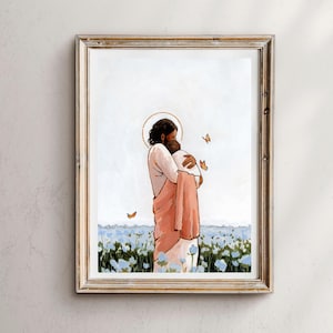 Op de afbeelding: Ingelijste kunstdruk met een figuur met een halo die een andere figuur omarmt in een veld met blauwe bloemen. De figuren dragen vloeiende gewaden. Vlinders zijn verspreid over de sc&egrave;ne. De lijst is lichtgoudkleurig.
