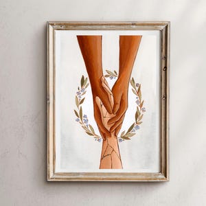 Op de afbeelding: Twee handen met verschillende huidskleuren zijn in elkaar gegrepen, waarbij de bovenste hand de onderste hand vasthoudt. De handen worden omringd door een krans van groene bladeren en paarse bloemen.