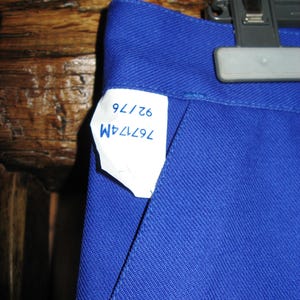 May include: A blue pair of pants with a white tag that says "76724M 62/76".