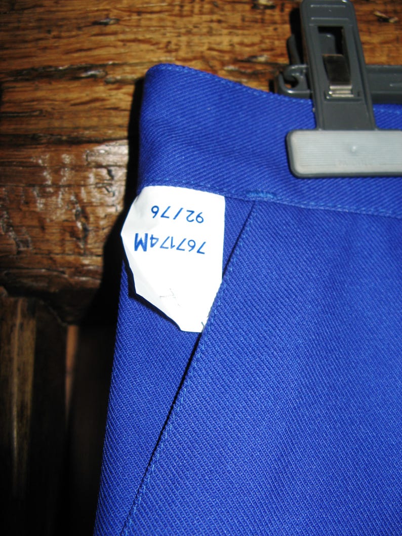 May include: A blue pair of pants with a white tag that says "76724M 62/76".