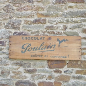 Un muy bonito panel de caja de madera francés vintage para chocolate Poulain