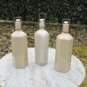 Tre belle vecchie bottiglie di gres color crema francese con tappi originali