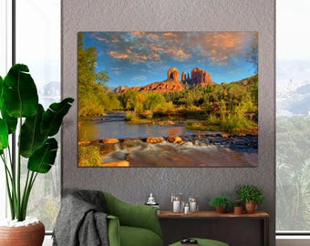 May include: A scenic landscape photograph featuring a red rock formation in the distance, a flowing river in the foreground, and lush green trees and foliage.
