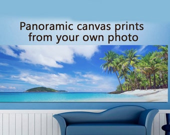 May include: A panoramic canvas print featuring a tropical beach scene with palm trees, white sand, and turquoise water. The print is displayed on a wall in a room with a blue couch and white wainscoting. The text "Panoramic canvas prints from your own photo" is displayed above the print.