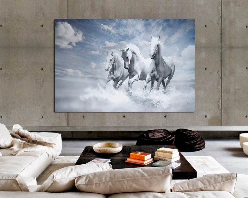 May include: Four white horses run through a field of clouds. The horses are running in a line, with the lead horse looking directly at the viewer. The sky is a light blue with white clouds.