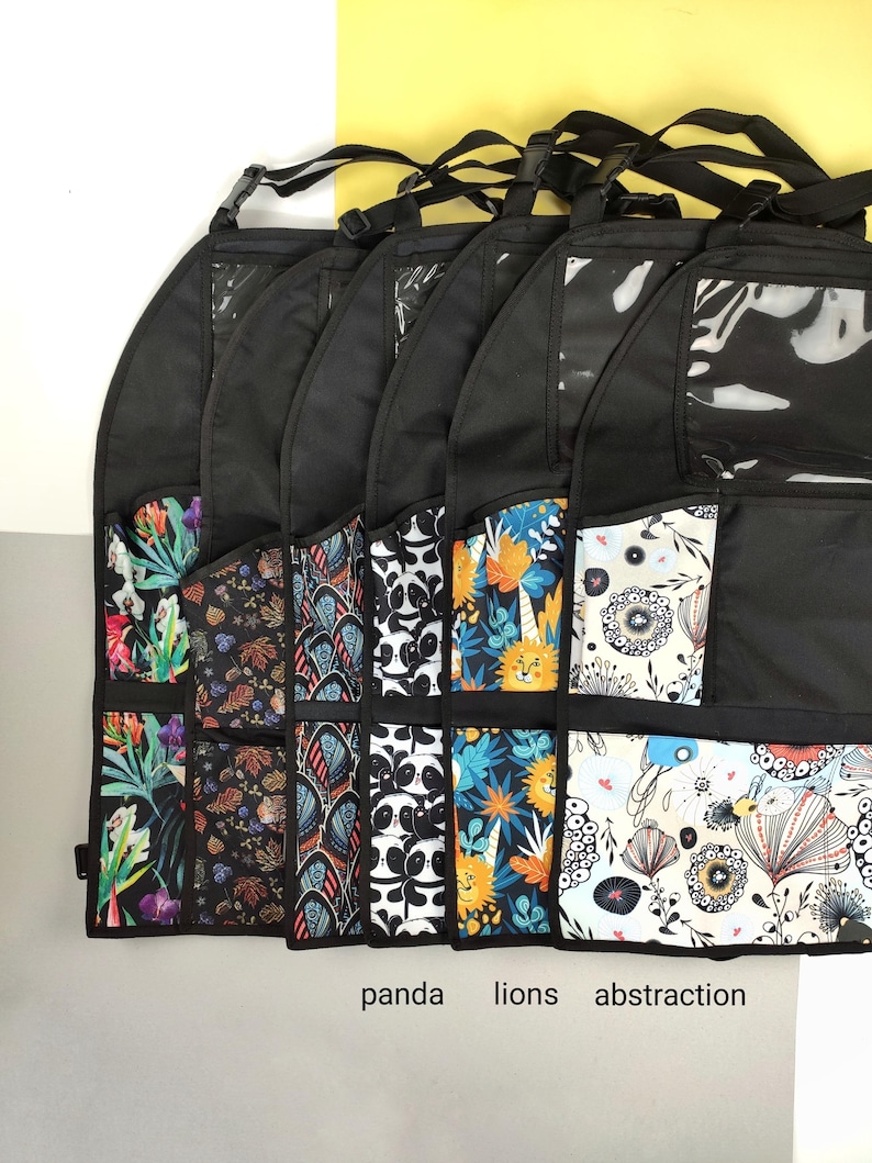May include: Six black fabric organizers with clear plastic windows and multiple pockets. The organizers have different colorful patterns, including tropical leaves, geometric designs, pandas, lions, and abstract flowers. The text "panda", "lions", and "abstraction" is printed below the organizers.