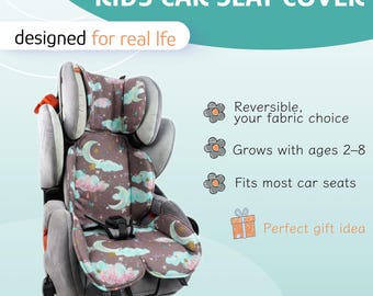 May include: A kids car seat cover featuring a brown fabric with a pattern of light blue clouds, yellow crescent moons, and stars. The text reads: KIDS CAR SEAT COVER, designed for real life, Reversible, your fabric choice, Grows with ages 2-8, Fits most car seats, Perfect gift idea.