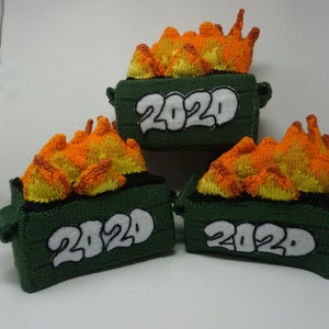 May include: Three green knitted trash cans with orange and yellow flames on top. Each can has the year 2020 written on the front in white.