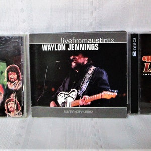 May include: Three Waylon Jennings music CDs. The CDs feature album art with images of Waylon Jennings. The titles include "Waylon Live," and "livefromaustintx." The CD cases are in plastic jewel cases.