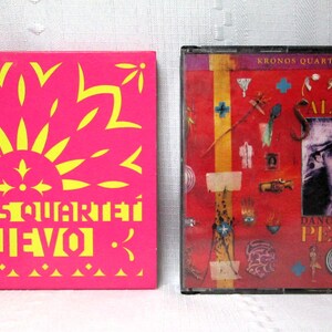 May include: Two music albums. The first is a bright pink CD case with yellow text that reads "Kronos Quartet Nuevo". The second album has a red background with the text "Kronos Quartet Plays Terry Riley" and "Salome Dances for Peace".