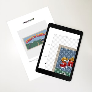 May include: A cross-stitch pattern for a Santa Carla sign, inspired by the movie The Lost Boys. The pattern is displayed on a tablet screen with a grid overlay. The sign is in a retro style with a yellow, orange, red, and blue color scheme.