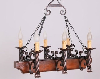 May include: A wrought iron chandelier with six candle-style lights. The fixture has a dark wood base and is suspended by chains. The text "РОЖЕН 6" and "A ROJ 6" are visible.