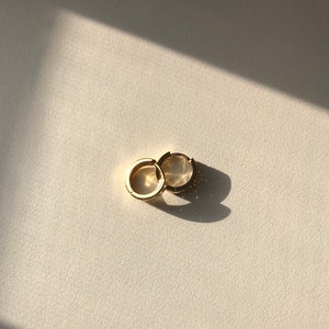 May include: A pair of gold hoop earrings. The earrings are simple and elegant, and they would be a great addition to any jewelry collection.