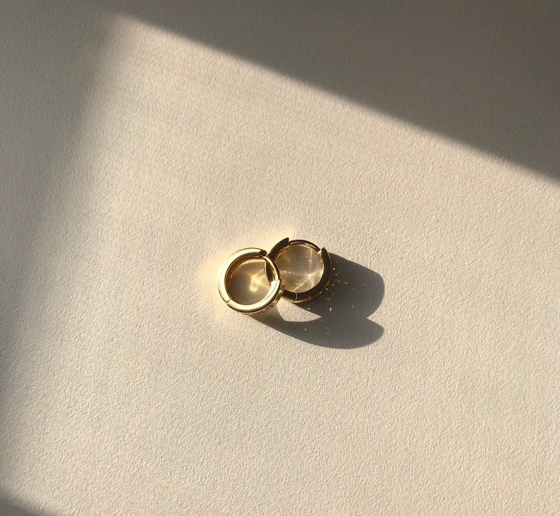 May include: A pair of gold hoop earrings. The earrings are simple and elegant, and they would be a great addition to any jewelry collection.