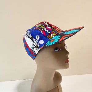 May include: A colorful baseball cap with a blue, red, white, and black patterned design. The cap has a curved brim and a black underside.
