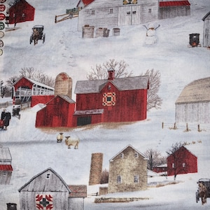 May include: A wintery scene with a variety of red and gray barns with red roofs and white snow on the ground. Some of the barns have a quilt block pattern on the side.