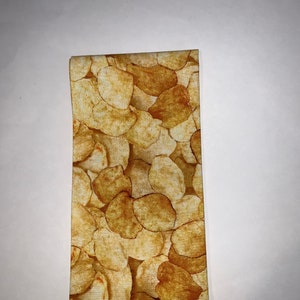 May include: A yellow and brown fabric with a pattern of potato chips.