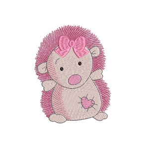 Puede incluir: Un erizo bordado de color rosa con un lazo rosa y un corazón rosa en el pecho.