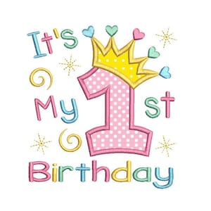 Puede incluir: Diseño bordado con el texto "It's My 1st Birthday". El número 1 es rosa con lunares blancos y está coronado con una corona amarilla con detalles de corazón y gemas azul-verdes. El texto es de varios colores pastel.