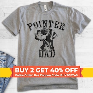 May include: A heather grey short-sleeve t-shirt featuring a black graphic of a dog wearing sunglasses. The text POINTER DAD is printed in a distressed black font above and below the dog illustration, centered on the front of the garment.