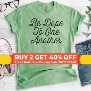 May include: Green t-shirt with the text "Be Dope To One Another" in black. The text has a distressed look. There is a sale banner at the bottom that says "BUY 2 GET 40% OFF Entire Order! Use Coupon Code: BUY2GET40"