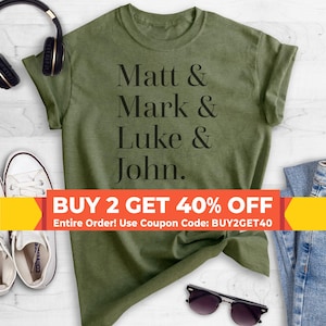 May include: A green t-shirt with the text "Matt & Mark & Luke & John." printed in black. The text is centered on the shirt. The shirt is laid flat on a white surface. A yellow and white banner at the bottom of the image reads "BUY 2 GET 40% OFF Entire Order! Use Coupon Code: BUY2GET40".