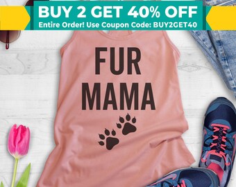 May include: A pink tank top with the text "FUR MAMA" in black lettering and two paw prints in black. The tank top is on a white surface with a pair of blue jeans and a pair of sneakers.