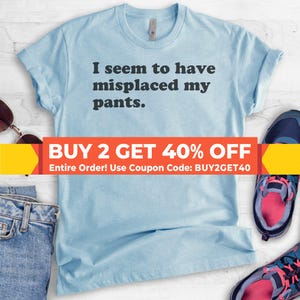 May include: Light blue t-shirt with the text "I seem to have misplaced my pants."  The text is in black and the shirt has a distressed look.  The image also includes a sale banner that says "BUY 2 GET 40% OFF Entire Order! Use Coupon Code: BUY2GET40"