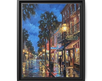 May include: A framed canvas print of a nighttime street scene. The artwork depicts a wet street with reflections of lights, palm trees, and buildings. The street sign reads "King St. Charleston."