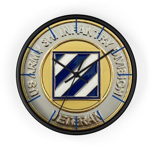 May include: A round wall clock with a black frame. The clock face features the words "US ARMY 3rd INFANTRY DIVISION VETERAN" around the edge. The center has a gold and silver design with a blue and white striped square.