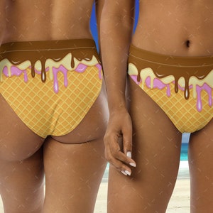May include: A brown and white bikini bottom with a waffle cone design and pink and brown dripping ice cream. The bikini bottom is on a model.