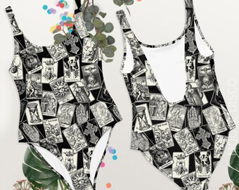 May include: Black and white one-piece swimsuit with a pattern of tarot cards. The swimsuit has a scoop neck and a racerback.