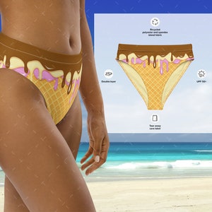 May include: A brown and pink ice cream cone print bikini bottom with a double-layer design. The fabric is made from recycled polyester and spandex blend. The bikini bottom has a tear-away care label and offers UPF 50+ sun protection.