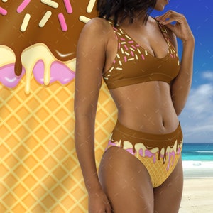 May include: A brown and pink bikini with a waffle cone and ice cream design. The top and bottom of the bikini have a brown chocolate-like design with pink and white sprinkles. The bottom of the bikini has a pink and white ice cream design with a waffle cone pattern.