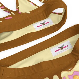 May include: Brown and white swimsuit with pink and white trim. The swimsuit has a moose logo with the text "MOOSE DISCO" and the website "www.moosedisco.co.uk".