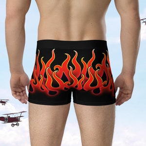 May include: Black boxer briefs with a vibrant flame design in red and yellow. The underwear features a bold, eye-catching pattern, perfect for those who want to make a statement. The brand name "MOOSE DISCO" is visible on the right side.