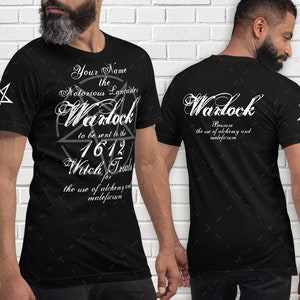 May include: Black t-shirt with white text and a pentagram design. The front of the shirt reads "Your Name the Notorious Lancaster Warlock to be sent to the 1612 Witch Trials for the use of alchemy and maleficium." The back says "Warlock Beware the use of alchemy and maleficium."