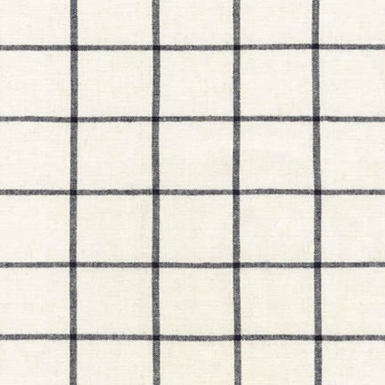 Pu&ograve; includere: Tessuto color crema con un motivo a griglia di linee blu navy scuro. Le linee si intersecano per creare quadrati uniformemente distanziati. Il tessuto ha un aspetto leggermente strutturato.