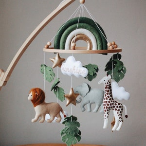Baby Safari Mobile mit Regenbogen | Afrika Kinderzimmer Filz Giraffe Löwe Elefant Monstera Blätter Krippe Sterne Wolken