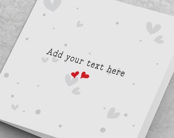 May include: A white card with a gray background and a light gray pattern of hearts. The text "Add your text here" is printed in black on the card. Two red hearts are in the center of the card.