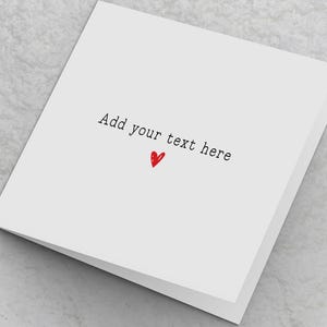 May include: A white folded card with the text "Add your text here" in black and a small red heart. The card is blank inside, ready for personalization. Ideal for a greeting card or a special message.